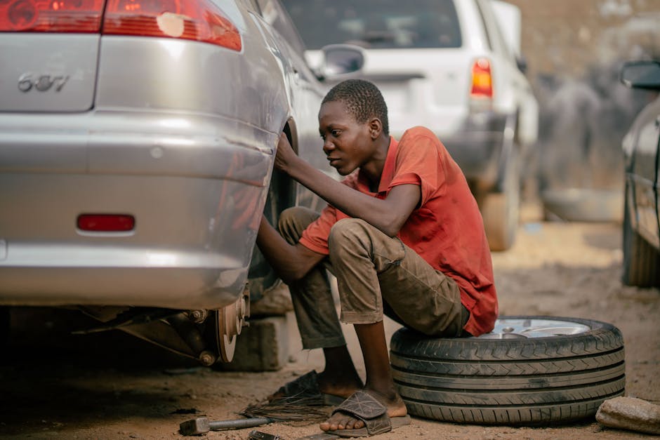 Mechanic professionally changing a car tire in a bright workshop